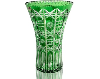 May include: A tall, emerald green glass vase with a cut crystal design. The vase has a wide mouth and a narrow base.