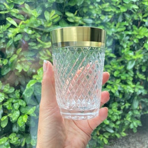 May include: A clear glass tumbler with a gold rim. The glass has a diamond pattern.