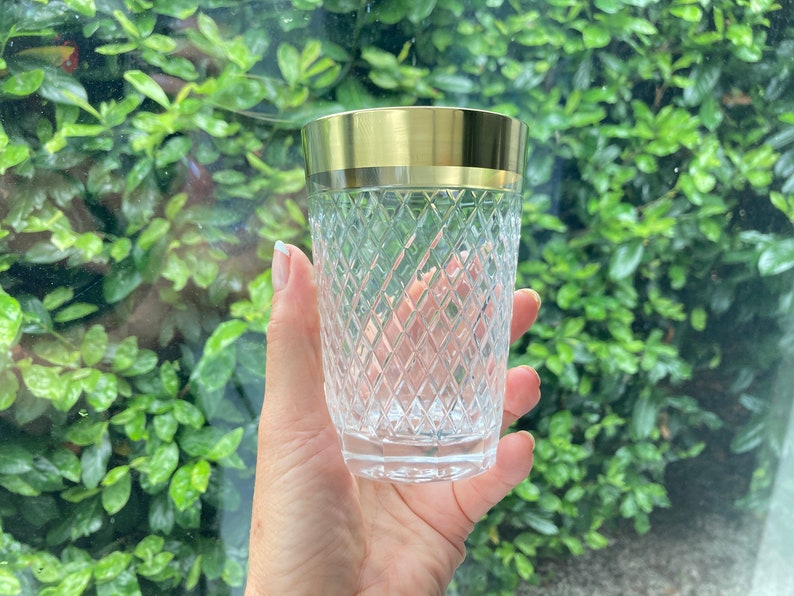 May include: A clear glass tumbler with a gold rim. The glass has a diamond pattern.