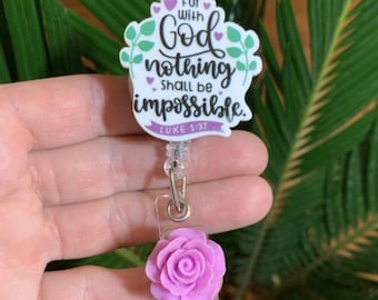 May include: A white badge holder with a purple flower charm. The badge holder has a quote that reads "For with God nothing shall be impossible. Luke 1:37"