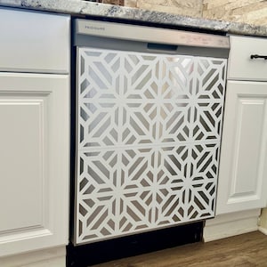 May include: A stainless steel dishwasher with a white geometric pattern on the front. The dishwasher is labelled "FRIGIDAIRE" and has a handle on the top right corner.