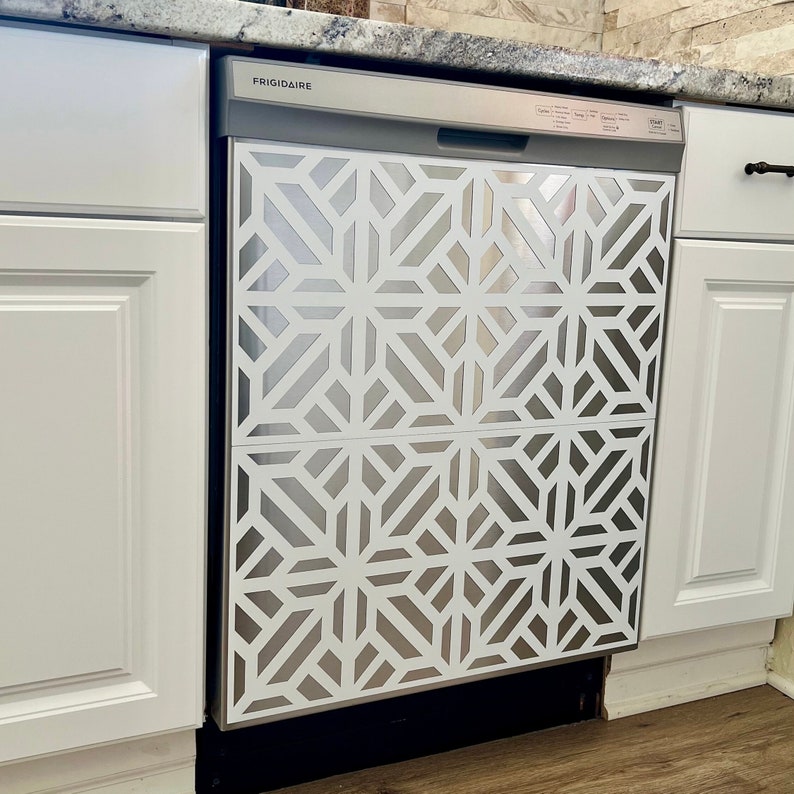 May include: A stainless steel dishwasher with a white geometric pattern on the front. The dishwasher is labelled "FRIGIDAIRE" and has a handle on the top right corner.