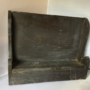 May include: A dark brown wooden shelf with a single shelf. The shelf is made of rough-hewn wood and has a rustic appearance.