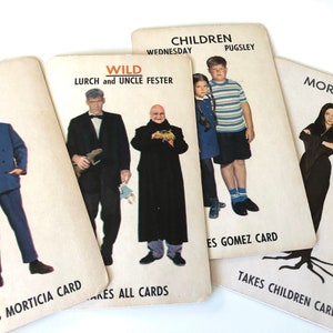 May include: Four vintage playing cards featuring The Addams Family characters. The cards display Gomez, Lurch, Uncle Fester, Wednesday, Pugsley, and Morticia with text labels including names and game instructions like Takes Morticia Card and Wild.