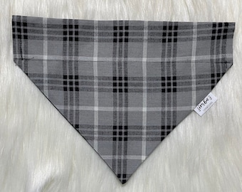 May include: Gray and black plaid dog bandana with a white label that says "Jimba's Creatives".