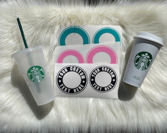 May include: A set of two reusable Starbucks-style cups with lids and straws. The cups are clear and have a green Starbucks logo. The set also includes two black and white stickers with the text "Your Custom Text Here" and two teal and pink stickers.