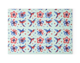 Pode incluir: Um item decorativo retangular com um padrão repetido de beija-flores e flores vermelhas e azuis em um fundo verde claro. Pequenas estrelas brancas estão espalhadas por todo o design. As flores alternam entre vermelho e azul.