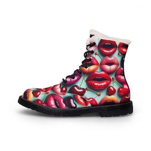 May include: A white ceramic mug with a black handle and the text "But First, Coffee" in a bold, black font. The mug is set against a blurred background, suggesting a cozy setting. The mug appears to be approximately 4 inches tall.