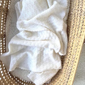 White baby blanket knitted of soft merino wool for baby girl or baby boy, perfect baby gift
