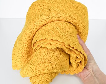 Manta amarilla de lana merino tejida a cuadros para bebé, ideal para una habitación infantil luminosa.