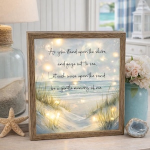 Może przedstawiać: Oprawiony obraz sceny na plaży z tekstem "As you stand upon the shore, and gaze out to sea, Let each wave upon the sand be a gentle memory of me." Grafika przedstawia piaszczystą plażę, ocean i trawę wydmową.