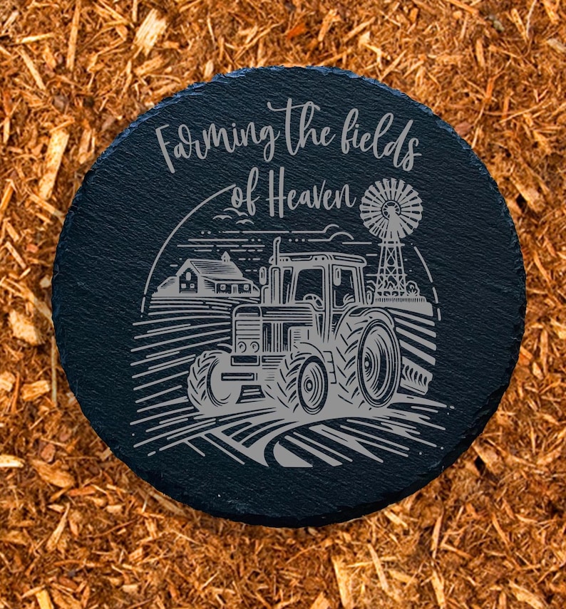 May include: Black slate round sign with the text "Farming the fields of Heaven" and a black and white illustration of a tractor in a field.