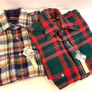 Puede incluir: Dos camisas de franela a cuadros. Una camisa presenta un patr&oacute;n de amarillo, naranja, verde y azul marino. La otra camisa tiene un patr&oacute;n de cuadros rojo y verde. Ambas camisas tienen cierres de botones y etiquetas colgantes.
