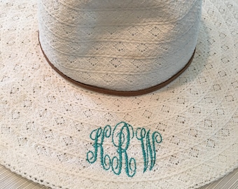 May include: White crochet sun hat with a brown leather band and a teal monogram "RRW" embroidered on the front.
