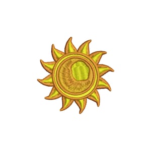 May include: A yellow and orange embroidered sun with a stylized design. The sun has a yellow center and orange rays.
