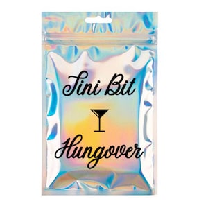 May include: A holographic, iridescent pouch with a zip closure. The text "Tini Bit Hungover" is written in black script, with a martini glass icon. The pouch has a small hole at the top for hanging.