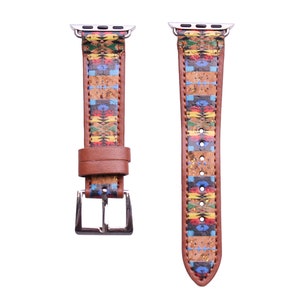May include: A brown leather watch band with a colorful geometric pattern. The band has a silver buckle and is compatible with Apple Watches.