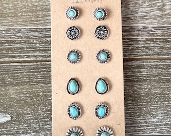 May include: Set of six pairs of turquoise and silver stud earrings. The earrings are displayed on a card with the word "tipi" printed on it.