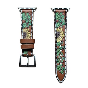 May include: A brown leather Apple Watch band with a white and green cactus and sunflower design.