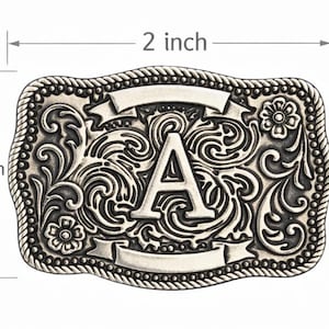 May include: Silver-colored rectangular belt buckle, 2 inches wide and 1.5 inches tall, with an ornate floral and scroll design. The letter "A" is prominently displayed in the center, with two blank banner shapes above and below. The edges are rope-like.