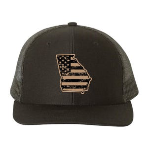 May include: A dark gray trucker hat featuring a tan outline of the state of Georgia with a distressed American flag design. The hat has a mesh back and a curved brim. The front panel displays the state outline and flag.