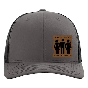 May include: A gray and black trucker hat with a brown patch that says "Don't Hate Participate" and features a silhouette of three people, two women and one man.