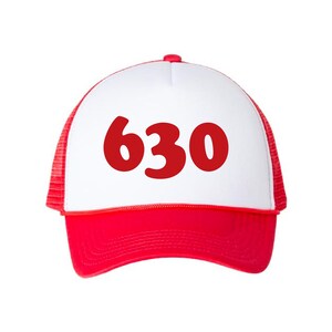 May include: A red and white trucker hat featuring the number "630" in bold red text. The hat has a white front panel, a red peak, and a red mesh back.