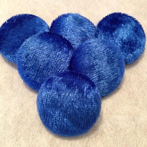 May include: Six blue velvet buttons, each with a slightly different texture and sheen.