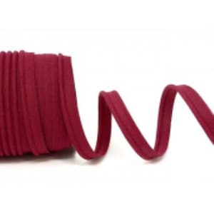 May include: A roll of burgundy red cotton cord, folded and coiled, with a length of the cord extending out to the right.