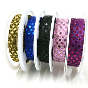May include: Five spools of sequined ribbon in gold, blue, black, pink, and purple.