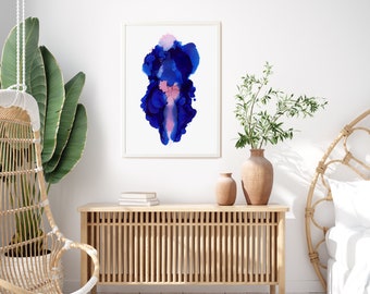Könnte beinhalten: Ein gerahmtes abstraktes Gemälde mit blauen und rosafarbenen, aquarellartigen Wirbeln auf weißem Hintergrund. Das Gemälde hängt an einer weißen Wand über einem Holzkasten mit einem geflochtenen Rattanstuhl und einer Topfpflanze im Hintergrund.