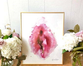 Könnte beinhalten: Ein gerahmtes Aquarellbild einer abstrakten Form in Rosa und Rot, die an eine Blume oder einen Teil des menschlichen Körpers erinnert. Das Bild ist auf weißem Hintergrund und hat einen goldenen Rahmen.