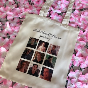 Könnte beinhalten: Eine cremefarbene Stofftasche mit dem schwarzen Text Which Edward Cullen are you today? über einem Raster aus acht verschiedenen fotografischen Bildern der Figur Edward Cullen aus der Twilight-Filmreihe, die verschiedene Gesichtsausdrücke zeigen.