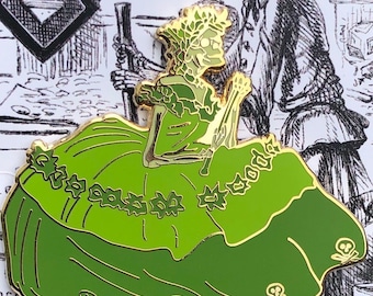 May include: Green enamel pin depicting a skeleton wearing a green dress with a floral design and skull accents. The pin is set against a white background with a black and white illustration of a skeleton.