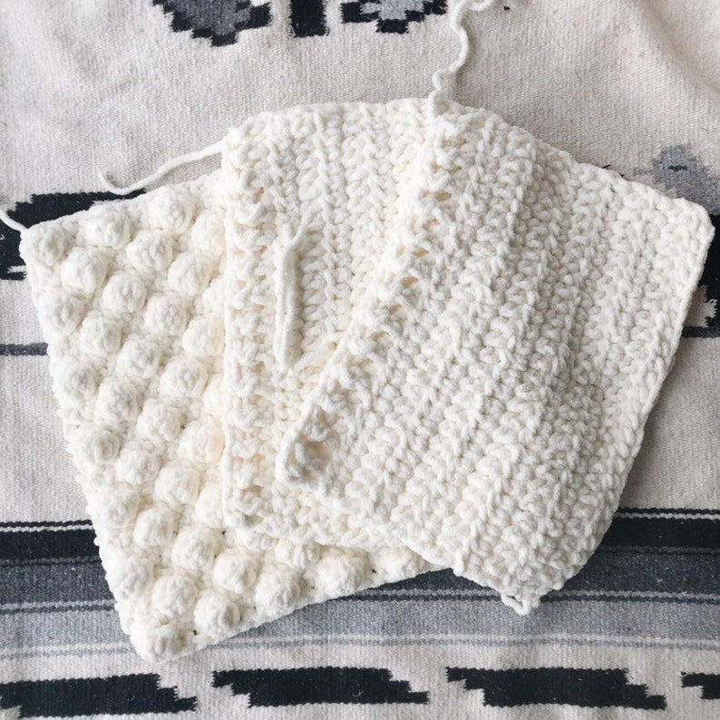 May include: Three white crocheted squares with different stitch patterns. The squares are stacked on top of each other.