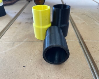 Op de afbeelding: Twee zwarte plastic buisverbinders en één gele plastic buisverbinder. De verbinders zijn van verschillende grootte.