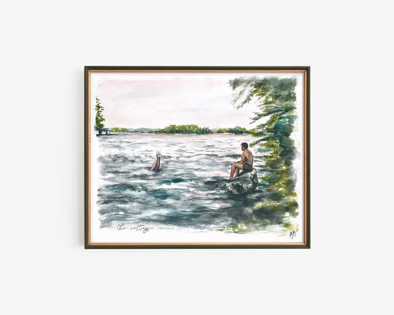 May include: Watercolor painting of a lake scene with two people. One person is sitting on a rock, and another is diving into the water. The painting is framed in a dark green frame. The text "the cottage" is written at the bottom.