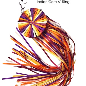 May include: A decorative ring with a circular design, featuring a vibrant array of colorful ribbons. The ribbons are in shades of purple, orange, yellow, and white. The text "Indian Corn 6" Ring" is visible at the top.