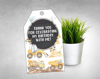 May include: Construction themed thank you tag with a chalkboard background. The tag features a yellow construction truck, a cement mixer, and a dump truck. The text on the tag reads "Thank you for celebrating my birthday with me!"