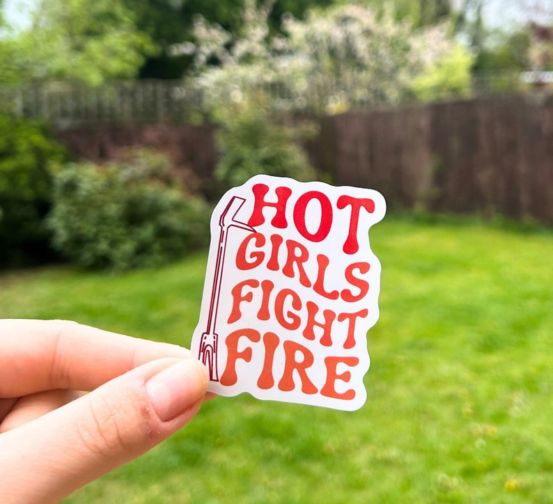 May include: White sticker with red text that reads "HOT GIRLS FIGHT FIRE" with a red outline of a fire hook.