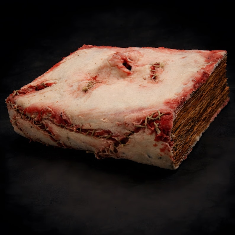 Side view of human skin face book, handmade dark art book highlighting spine structure and thick sculpted cover