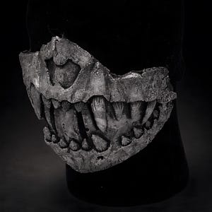 Three quarter view of fangs half mask, wearable dark art mask showing sculptural depth and asymmetrical design