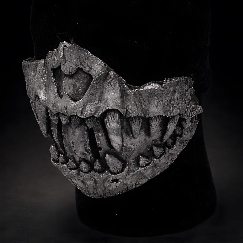 Three quarter view of fangs half mask, wearable dark art mask showing sculptural depth and asymmetrical design