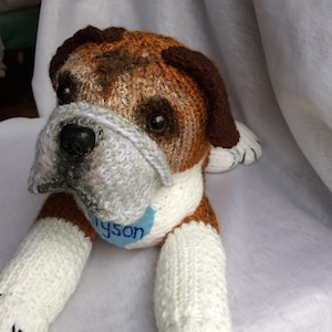 May include: A brown and white knitted bulldog plush toy with a blue tag that says "Tyson".