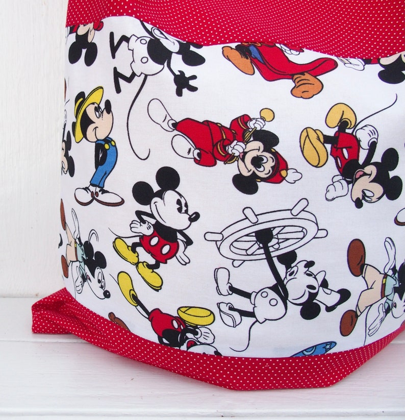 May include: Red and white fabric tote bag with a polka dot pattern. The bag features a repeating pattern of Mickey Mouse characters in various poses.