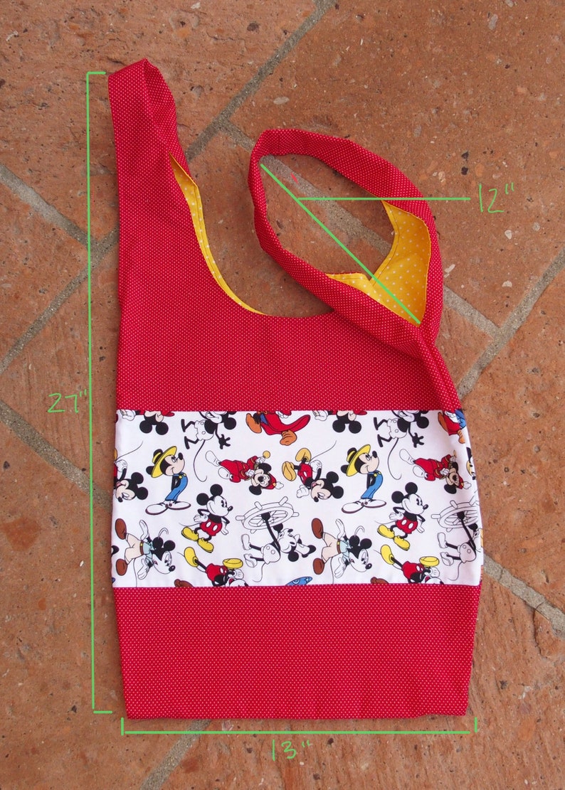 May include: Red and yellow fabric tote bag with a white panel featuring a Mickey Mouse print. The bag measures 12 inches wide by 21 inches tall and 13 inches long.