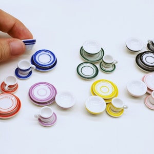 May include: A set of miniature teacups and saucers in various colours and patterns, including blue, green, yellow, pink, and red. The set includes a small bowl and a variety of teacups and saucers.