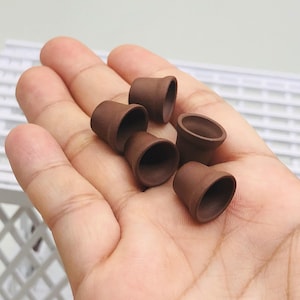 Op de afbeelding: Een verzameling van zes kleine terracotta potten, perfect voor miniatuurplanten of vetplanten. De potten zijn ongeglazuurd en hebben een rustieke, aardse uitstraling.