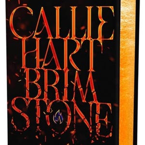 May include: A hardcover book titled "Brimstone" by Callie Hart. The cover is black with fiery orange lettering and accents. The book's pages have a golden-yellow edge. The text reads "#1 New York Times Bestselling Author" and "A Novel."