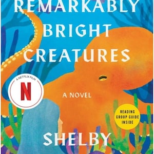 May include: The book cover for Remarkably Bright Creatures by Shelby Van Pelt features a large orange octopus and a person with blue hair against a blue underwater background with coral. It includes a Netflix film logo and a reading group guide sticker.